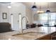 Close-up of the kitchen sink featuring granite countertops, modern faucet, and views of dining area at 826 Christina Cir, Oldsmar, FL 34677