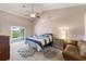 Bright main bedroom with ensuite access, vaulted ceiling, ceiling fan, and sliding glass door to backyard at 826 Christina Cir, Oldsmar, FL 34677