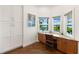 Bright office space featuring custom cabinets, bay windows, and dark wood flooring at 826 Christina Cir, Oldsmar, FL 34677