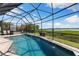 Sparkling screened-in pool, inviting hot tub, lush landscaping, and serene water views at 826 Christina Cir, Oldsmar, FL 34677