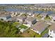 Beautiful aerial view of homes by a lake in a suburban neighborhood with well-manicured lawns and landscaping at 8607 Bower Bass Cir, Wesley Chapel, FL 33545