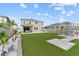 A view of backyard featuring artificial turf, landscaping, and a stone outdoor kitchen and bar at 8607 Bower Bass Cir, Wesley Chapel, FL 33545