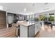 An open-concept kitchen and dining area featuring a large island, stainless steel appliances, and hardwood floors at 8607 Bower Bass Cir, Wesley Chapel, FL 33545