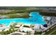 Aerial of the community lagoon showcasing clear blue water, recreational amenities, and beach areas for residents at 8607 Bower Bass Cir, Wesley Chapel, FL 33545