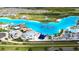 Aerial perspective of a community lagoon with a sandy beach, play structures, and recreational area at 8607 Bower Bass Cir, Wesley Chapel, FL 33545
