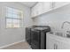 Laundry room with a washer, dryer, utility sink, and overhead cabinets at 8607 Bower Bass Cir, Wesley Chapel, FL 33545