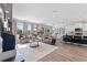 Bright and airy living area with a large sectional, modern lighting, and open access to the kitchen at 8607 Bower Bass Cir, Wesley Chapel, FL 33545