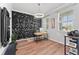 Modern office featuring a wood desk, geometric wall art, and lots of natural light at 8607 Bower Bass Cir, Wesley Chapel, FL 33545