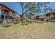Exterior view of multi-level townhomes with shaded, common backyard area and wood stairs to patios at 9031 Westchester Cir # 128, Tampa, FL 33604