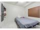 Simple bedroom featuring white tile floors, a plush bed, and ample natural light at 9031 Westchester Cir # 128, Tampa, FL 33604