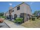 Angle shot of two-story townhouse showcasing siding and brick accents with walkway at 9031 Westchester Cir # 128, Tampa, FL 33604