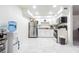 Bright kitchen with marble floors, stainless steel refrigerator, and white cabinetry at 9031 Westchester Cir # 128, Tampa, FL 33604