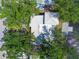 Aerial view of a single Gathering house with white roof and a private dock, surrounded by greenery at 9265 Treasure Ln Ne, St Petersburg, FL 33702