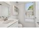 Bright bathroom with a sink, mirror, cabinet, and a window with blinds at 9265 Treasure Ln Ne, St Petersburg, FL 33702