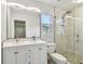 Bright bathroom featuring a large mirror, double sinks and a glass-enclosed shower at 9265 Treasure Ln Ne, St Petersburg, FL 33702