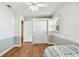 Comfortable bedroom featuring wood-look flooring, a ceiling fan, and natural light at 9265 Treasure Ln Ne, St Petersburg, FL 33702