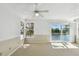 Large bedroom with lakeside balcony, ceiling fan and neutral carpet at 9265 Treasure Ln Ne, St Petersburg, FL 33702