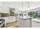 Updated kitchen with white cabinets, large island, modern appliances, and views of the water at 9265 Treasure Ln Ne, St Petersburg, FL 33702