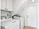 Efficient laundry room with modern washer and dryer units, plus built-in overhead cabinets at 9265 Treasure Ln Ne, St Petersburg, FL 33702