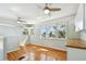 Bright living room with refinished hardwood floors, many windows, and overhead fans at 9265 Treasure Ln Ne, St Petersburg, FL 33702