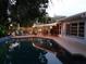 Gorgeous pool with outdoor lights and a full outdoor kitchen is perfect for entertaining guests at 930 S Lyndhurst St, Dunedin, FL 34698