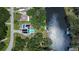 Aerial view showcasing a private pool, dock, and waterfront access, surrounded by mature trees and lush landscaping at 9303 Alice Ln, Riverview, FL 33578