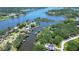 Stunning aerial view of a waterfront property with private docks, a pool, lush trees, and access to the intercoastal waterway at 9303 Alice Ln, Riverview, FL 33578