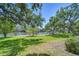 Lush backyard with mature trees leading to a tranquil waterfront, complete with a private dock and serene views at 9303 Alice Ln, Riverview, FL 33578