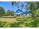 Expansive backyard featuring a well-maintained lawn, mature trees, and a gazebo-covered patio for outdoor relaxation at 9303 Alice Ln, Riverview, FL 33578