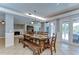 Spacious dining area with a large wood table, fireplace, and French door access to the pool at 9303 Alice Ln, Riverview, FL 33578