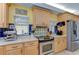 Kitchen features stainless steel appliances, light wood cabinets, and adjacent breakfast bar at 9303 Alice Ln, Riverview, FL 33578