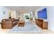 Spacious living room featuring a large TV, leather couch, and a seamless flow into the dining area at 9303 Alice Ln, Riverview, FL 33578