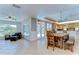 Open-concept living room with tile flooring, ceiling fan, breakfast bar, and access to outdoor patio at 9303 Alice Ln, Riverview, FL 33578