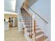 Interior view of staircase with wooden steps, railing, and a view of the modern kitchen at 9303 Alice Ln, Riverview, FL 33578