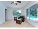 Cozy sunroom with a chair and ottoman offering serene views of the pool and waterfront through large windows at 9303 Alice Ln, Riverview, FL 33578