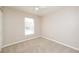 This bedroom features neutral carpet, a lighted ceiling fan, and a window for natural light at 10112 N Mitchell Ave, Tampa, FL 33612