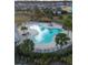 Aerial view of community pool, amenity area, and nearby homes with lush tropical landscaping at 10127 Newel Valley Loop, Riverview, FL 33569