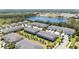Picturesque aerial view showcases the townhome community, lake, and wooded landscape at 10127 Newel Valley Loop, Riverview, FL 33569