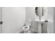 Bright half-bathroom featuring a pedestal sink and a white toilet at 10127 Newel Valley Loop, Riverview, FL 33569