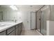 Bathroom showcasing double sink vanity, gray cabinets, and walk-in shower at 10127 Newel Valley Loop, Riverview, FL 33569