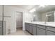 Bathroom featuring double sink vanity, gray cabinets, and walk-in shower at 10127 Newel Valley Loop, Riverview, FL 33569