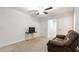 Neutral carpeted room with ceiling fan, TV on a small table, and cozy brown couch at 10127 Newel Valley Loop, Riverview, FL 33569
