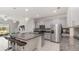 Open concept kitchen has stainless steel appliances, granite countertops, large island, bar seating, and light gray cabinetry at 10127 Newel Valley Loop, Riverview, FL 33569