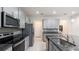 Modern kitchen features stainless steel appliances, granite countertops, stylish backsplash and light gray cabinetry at 10127 Newel Valley Loop, Riverview, FL 33569