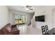 Open concept living room features a ceiling fan, sliding door to patio, and tile flooring at 10127 Newel Valley Loop, Riverview, FL 33569