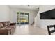 Spacious living area featuring tile floors, patio access, and modern lighting at 10127 Newel Valley Loop, Riverview, FL 33569
