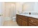 Bright bathroom with a vanity featuring a marble countertop, wood cabinets, and a shower and tub combo at 10502 Villa View Cir, Tampa, FL 33647