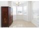 Dining area with bay window, chandelier, and decorative dark wood cabinet at 10502 Villa View Cir, Tampa, FL 33647