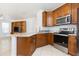 Kitchen with wood cabinets, stainless steel appliances and a counter overlooking the living room at 10502 Villa View Cir, Tampa, FL 33647