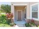 Inviting home entrance with vibrant flowers and a welcoming doormat, creating a warm first impression at 10502 Villa View Cir, Tampa, FL 33647